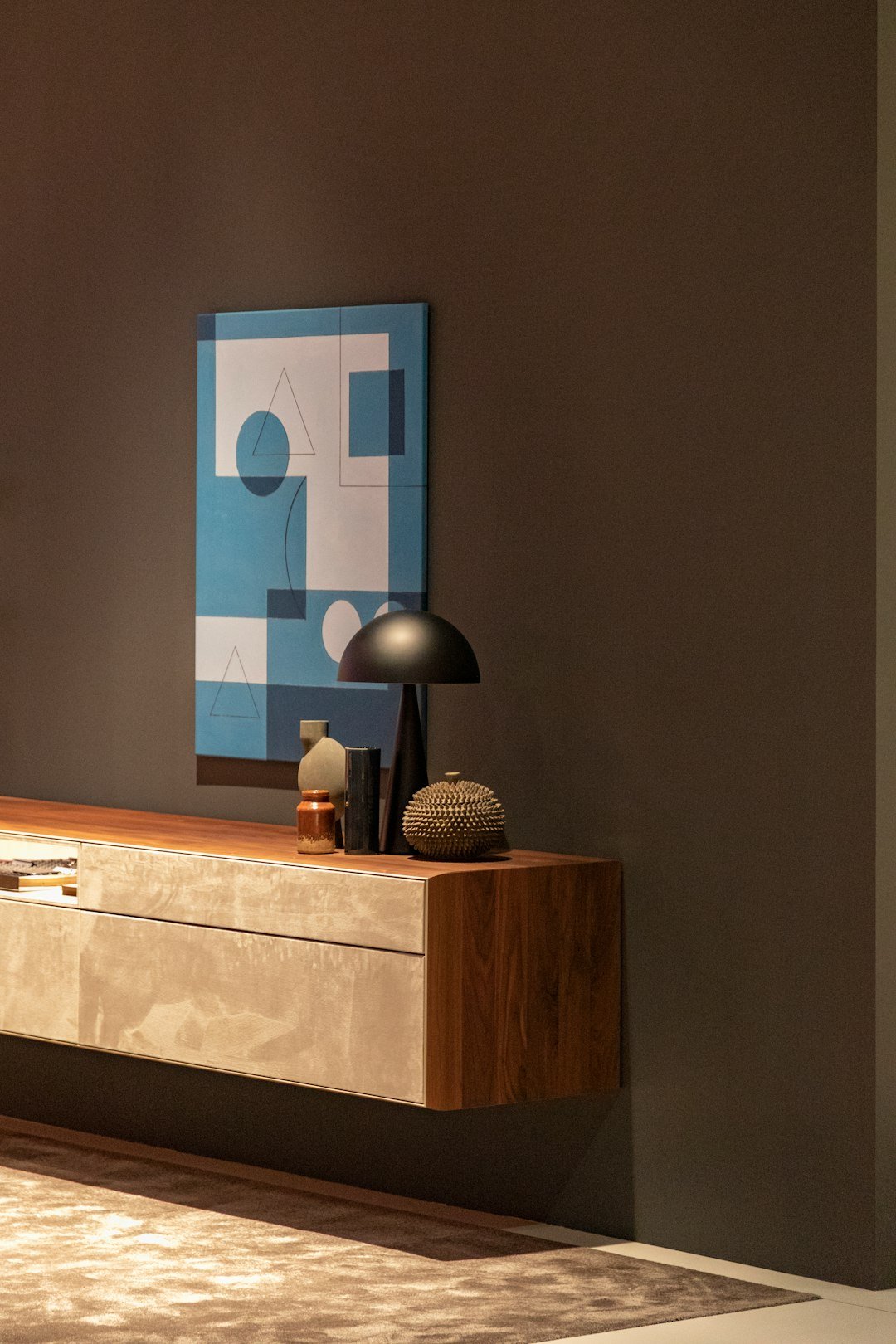 Grey table lamp on wooden sideboard
