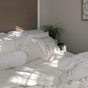 White linen bedding near green plant